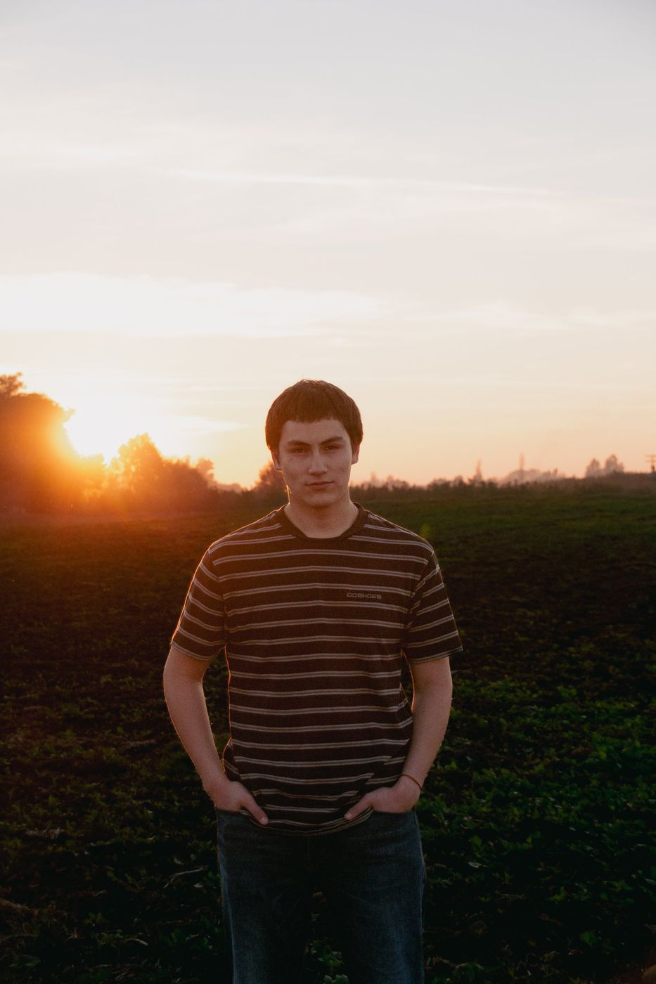 Retrato a contraluz con el sol poniéndose en el campo