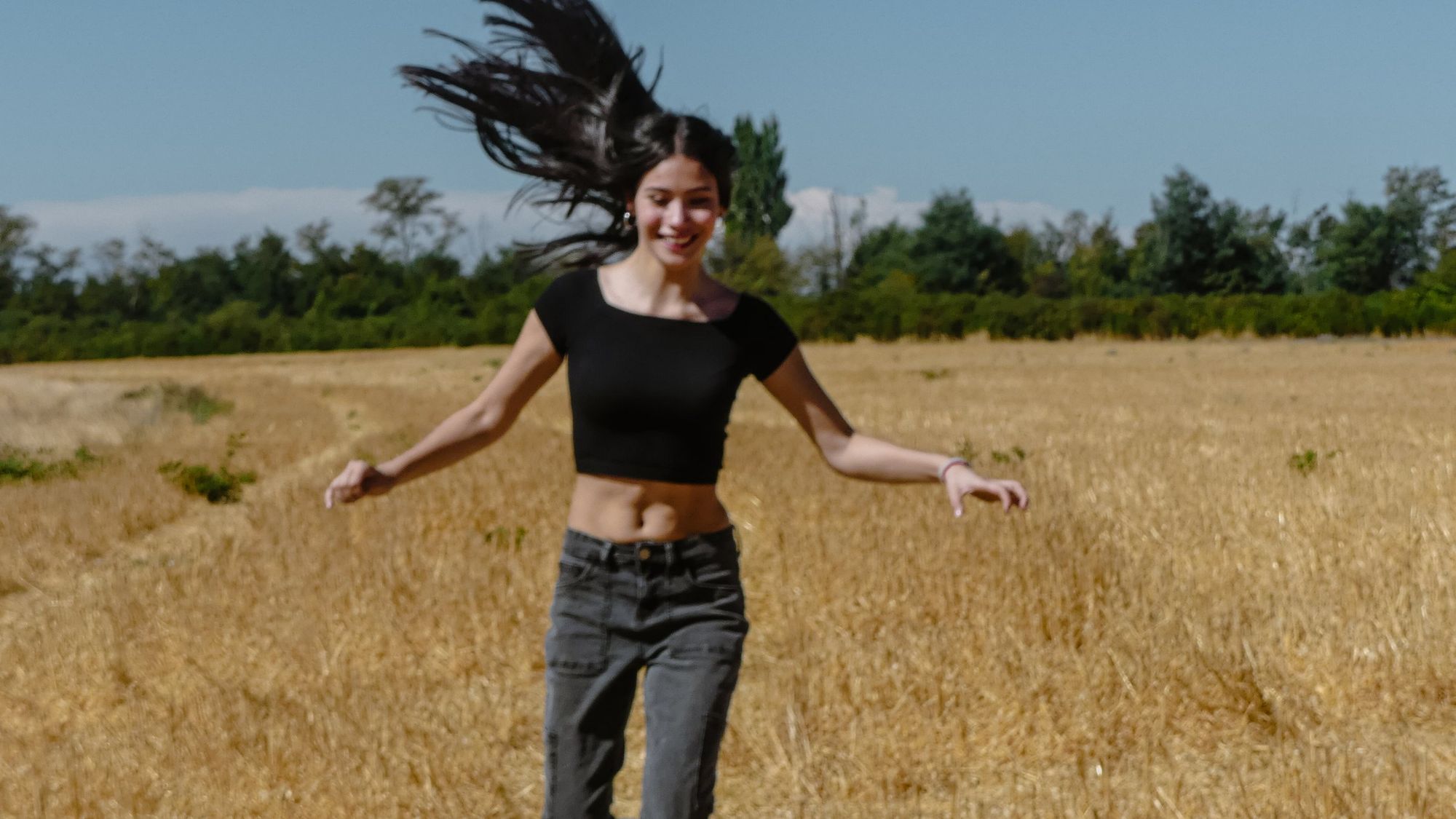 Joven corriendo por un campo de trigo